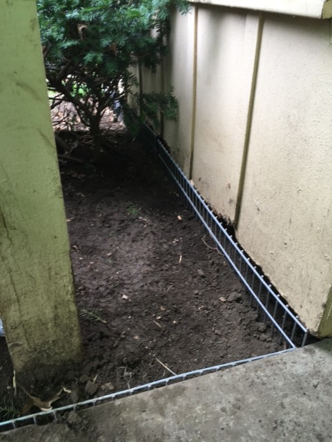 An exclusion barrier placed around a shed to ward off burrowing marmots